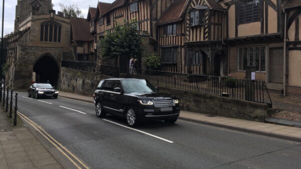 Black range rover driving up a road.