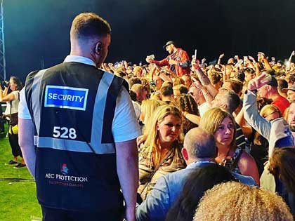 Man wearing a aec protection security vest at an event.